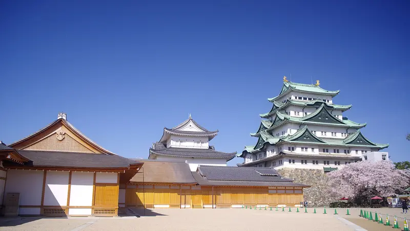 Nagoya Castle's main keep and small keep behind the roofs of Honmaru Palace
